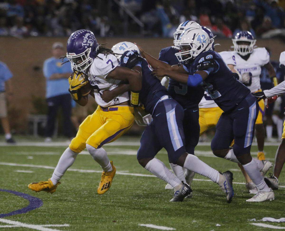 Northwestern’s Elijah Caldwell (7) is brought down by South Florence’s Terry Gordon (47) and Maki Matthews (42) Saturday at the Class 4A State Championship game in Columbia.