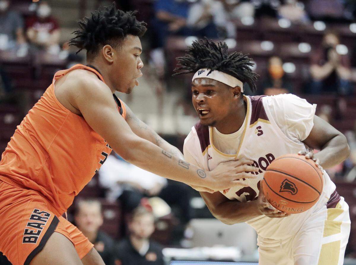 Winthrop’s D.J. Burns Jr. tries to get around Mercer’s Shannon Grant.