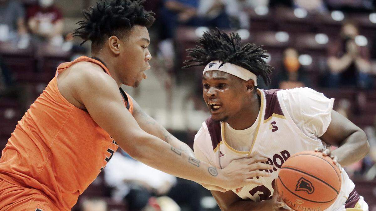 Winthrop’s D.J. Burns Jr. tries to get around Mercer’s Shannon Grant.