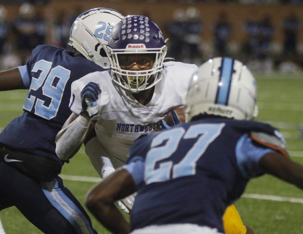 Northwestern’s Turbo Richard tries to avoid South Florence’s Cameron Coe (29) and Kemonte Rose (27).