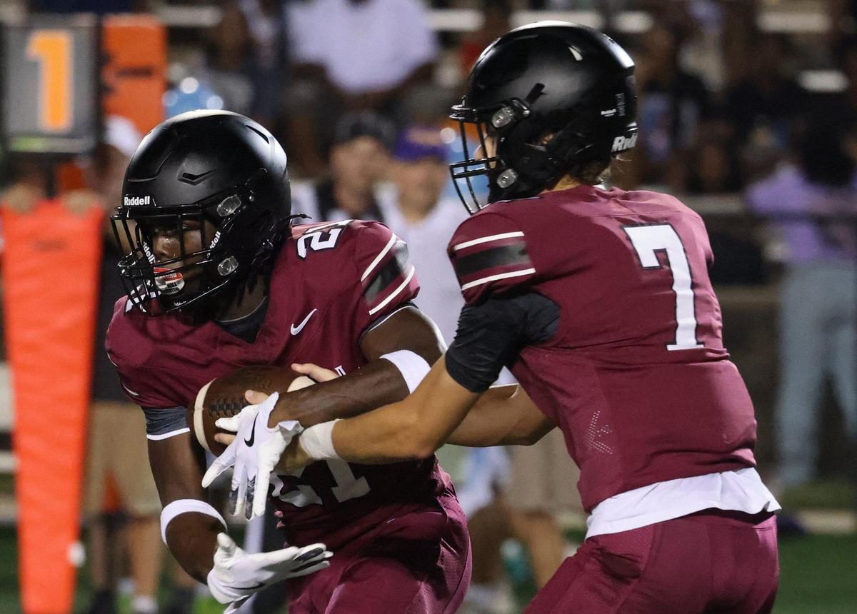 Rock Hill’s Ian Grisson hands off the ball to Zykel Reid Friday at the WRHI Football City USA scrimmage.