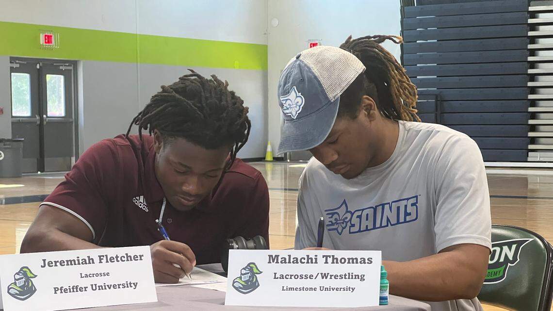 Jeremiah Fletcher (left) and Malachi Thomas (right) sign their ceremonial national letters of intent.