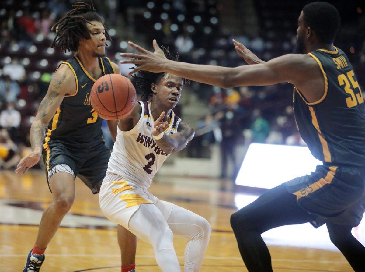 Winthrop’s Sin’Cere McMahon passes the ball around NC A&T’s Demetric Horton (3) and Collin Smith.