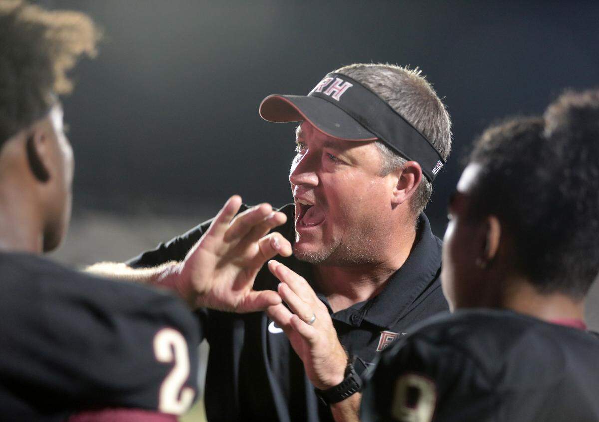 Rock Hill High varsity football coach Bubba Pittman talks to players during halftime at the 2021 WRHI Kickoff in Rock Hill.