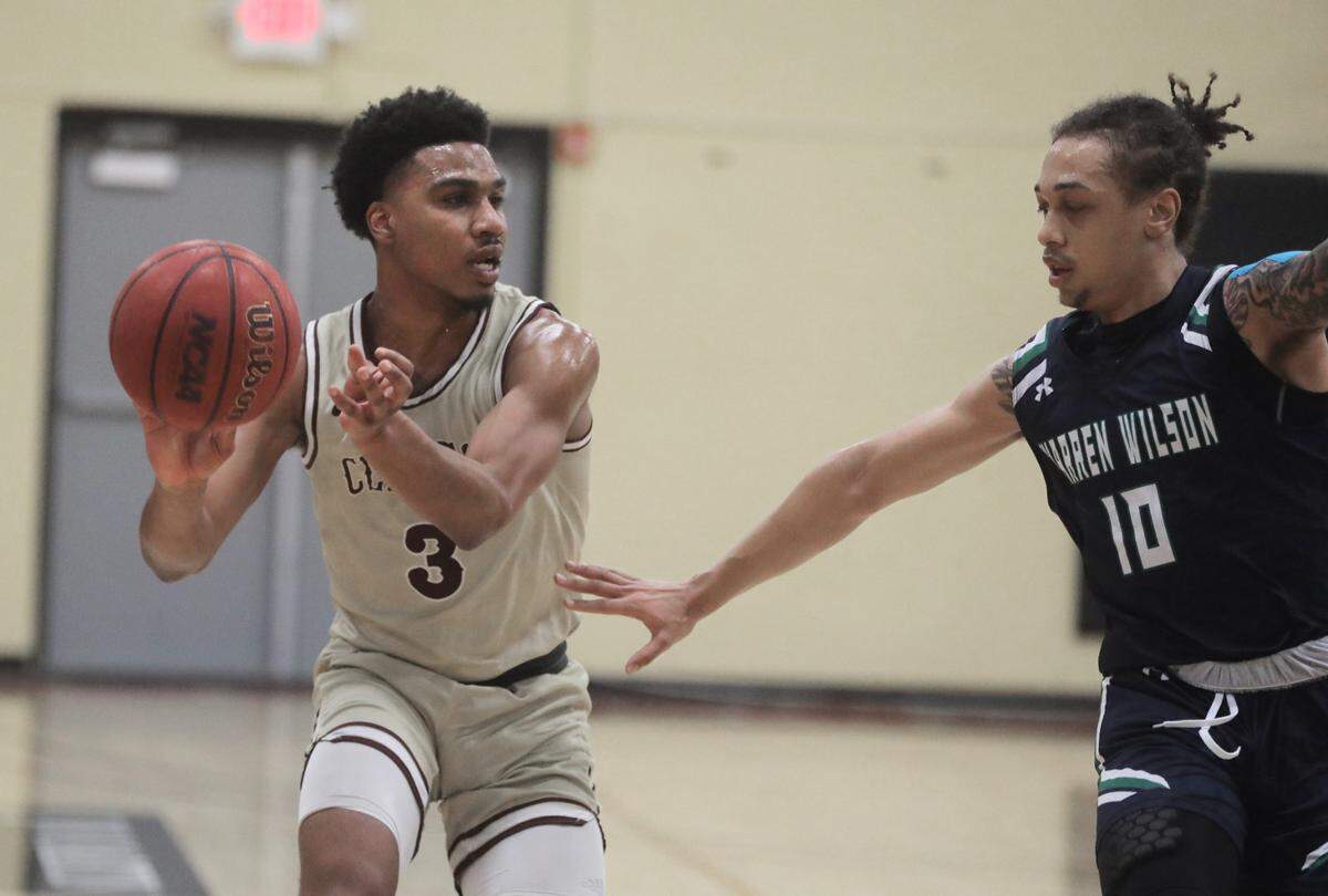 Clinton’s Jermirian Davis passes the ball around Warren Wilson’s Kris Carroll.