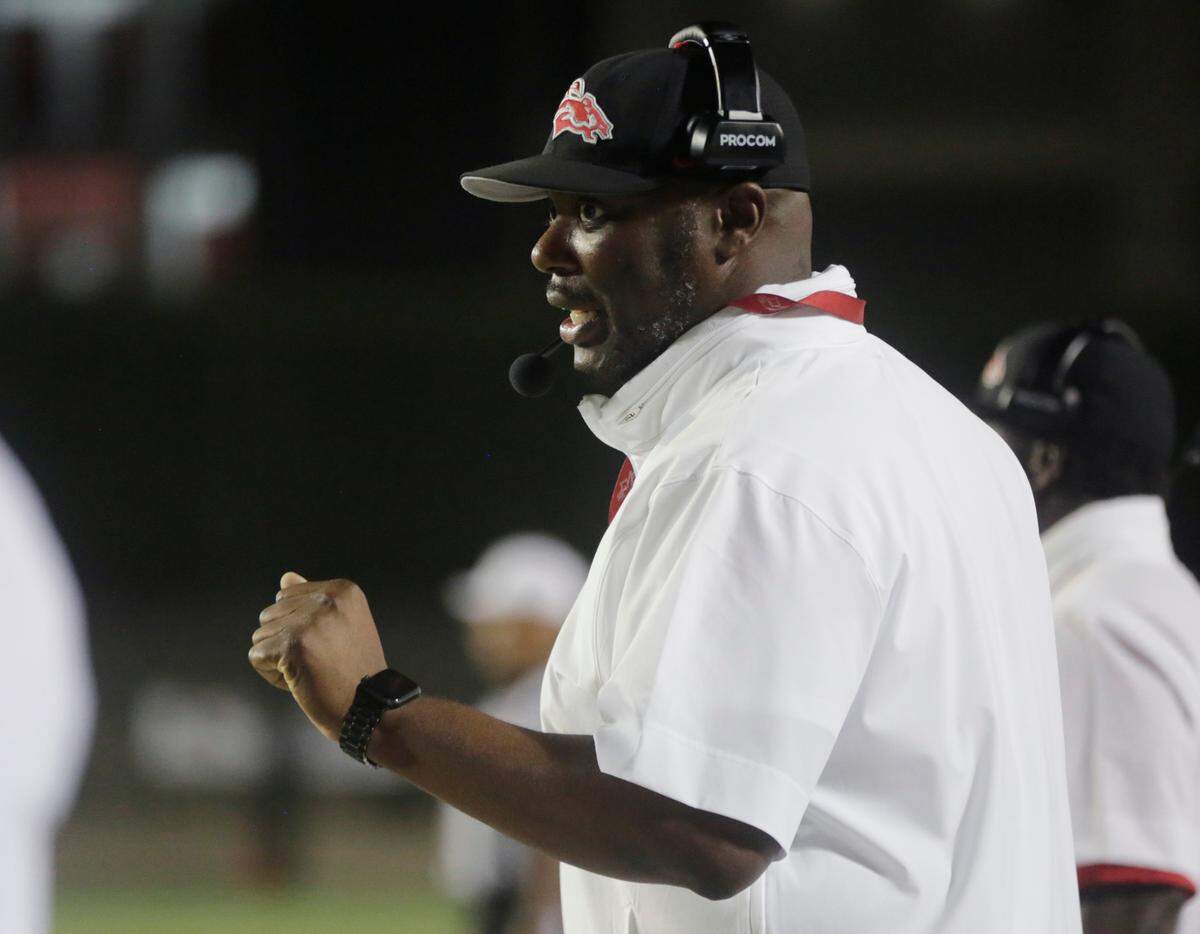 South Pointe High School football coach Bobby Collins talks to a player from the sideline Friday, Aug. 11, 2023 in Rock Hill, S.C.