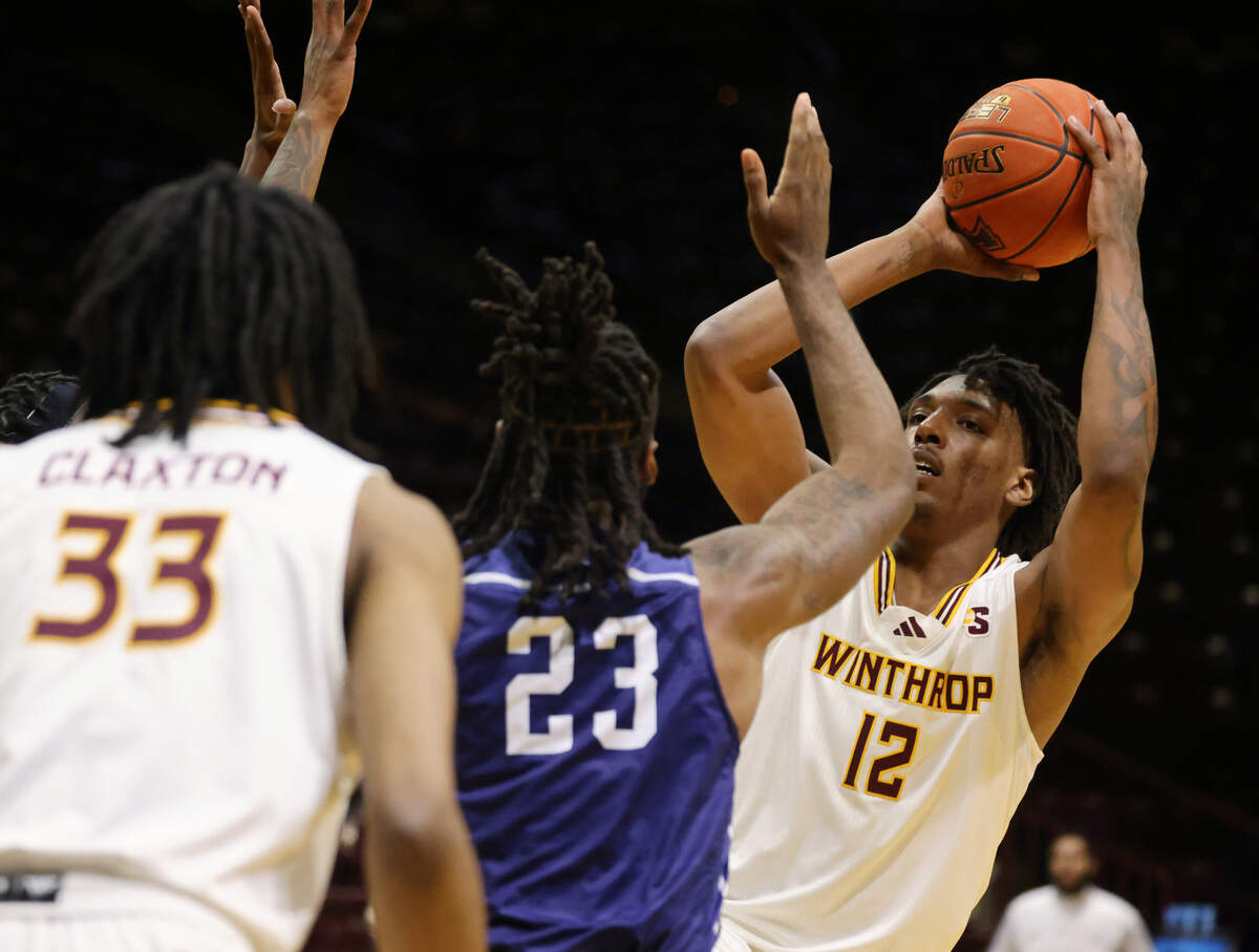 Winthrop’s K.J. Doucet tries the pass the ball to Chase Claxton, left, against Toccoa Falls’ Ryan McKenzie Friday at the Winthrop Coliseum.