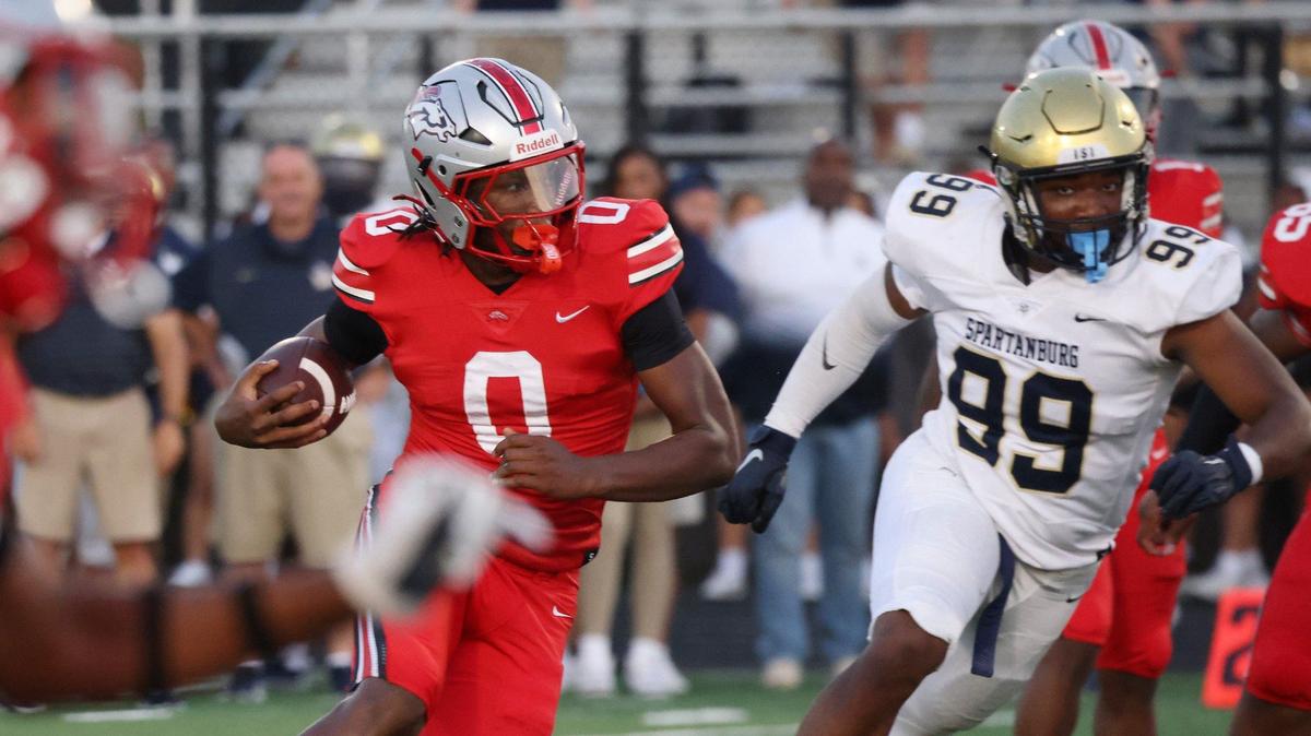 South Pointe’s J’Zavien Currence (0) is trailed by Spartanburg’s Cory Cheeks (99) Friday in Rock Hill.