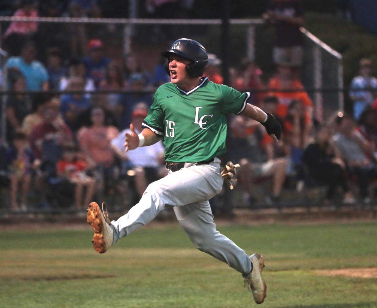 Legion’s Ethan Belk celebrates after scoring Tuesday during the region 2A baseball championships in Lancaster.