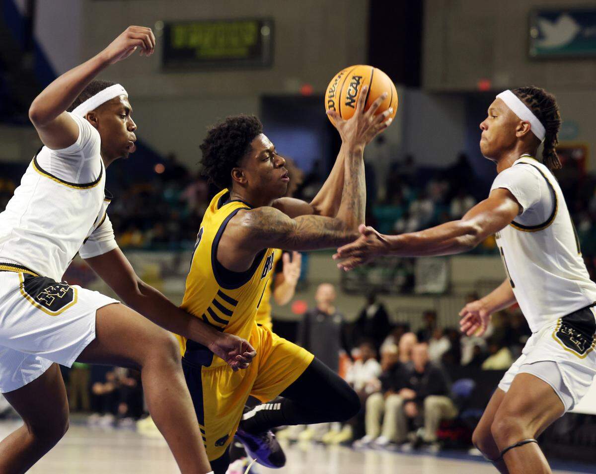 Lancaster’s Jordan Watford, center, tries to get to the basket around North Augusta’s Jamison Mckenzie, left, and Daron Dunbar Friday at the Class 4A state championships in Florence