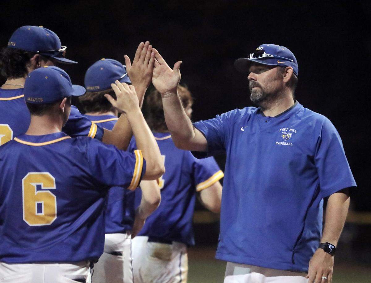 Fort Mill boys varsity baseball coach Travis Collier high-fives players after the team defeats Berkley.