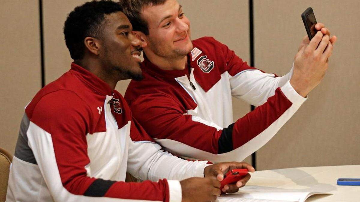South Carolina's Duane Notice, left, and Mindaugas Kacinas take a selfie during Wednesday’s SEC basketball media day in Charlotte. .