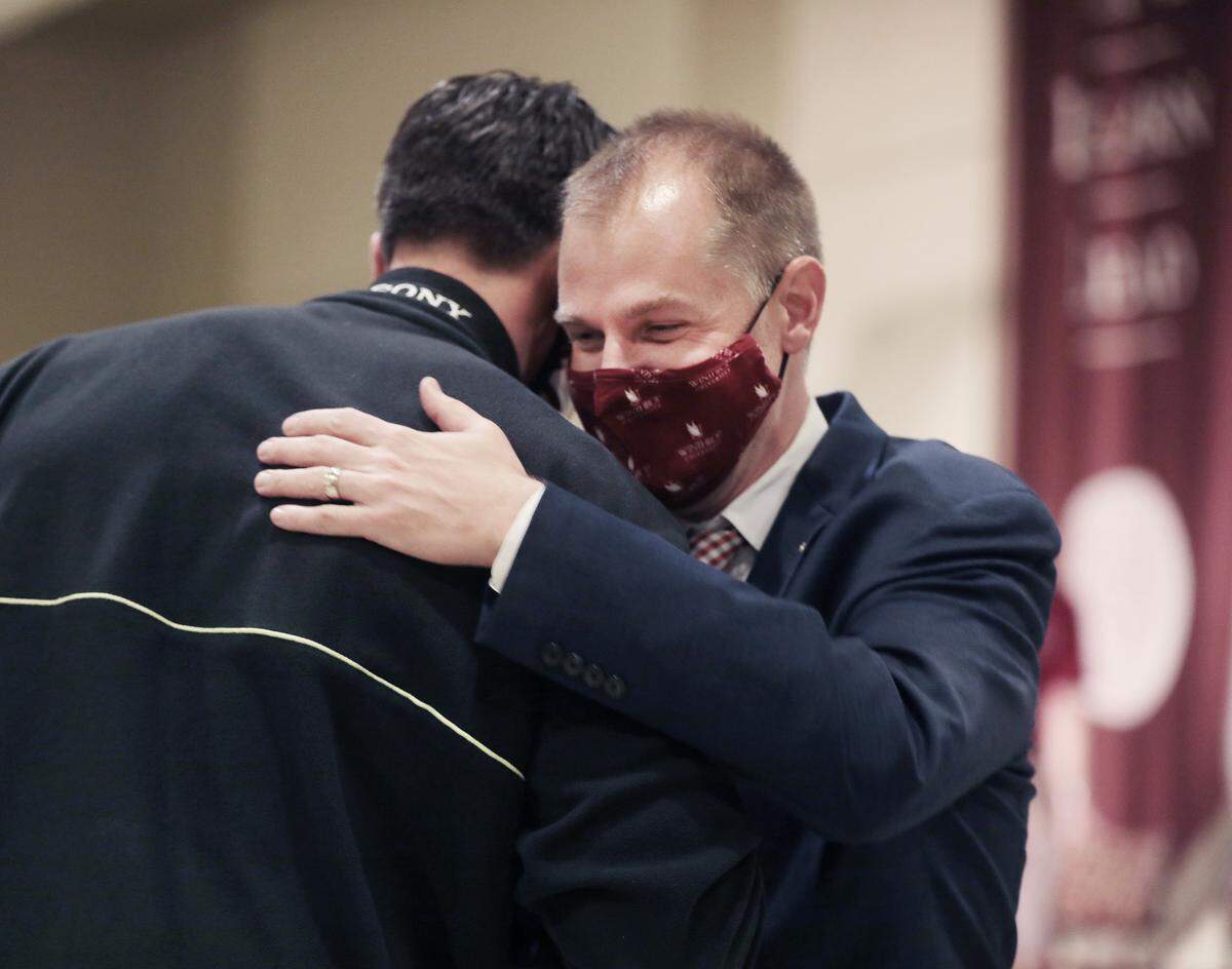 New Winthrop University men’s basketball coach Mark Prosser hugs player Tom Pupavac Friday.