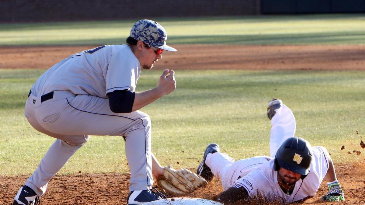 Winthrop baserunner Anthony Paulsen slides into first base as LaSalle’s Ben Faso tries to tag him.