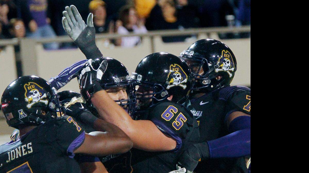 
East Carolina Pirates' Bryce Williams (80) celebrates his TD with Isaiah Jones (7), J.T. Boyd (65) and Dontae Levingston (71) during the first quarter of a game played between East Carolina Pirates and the Connecticut Huskies at Dowdy-Ficklen Stadium in Greenville, N.C.,on Oct. 23, 2014.
