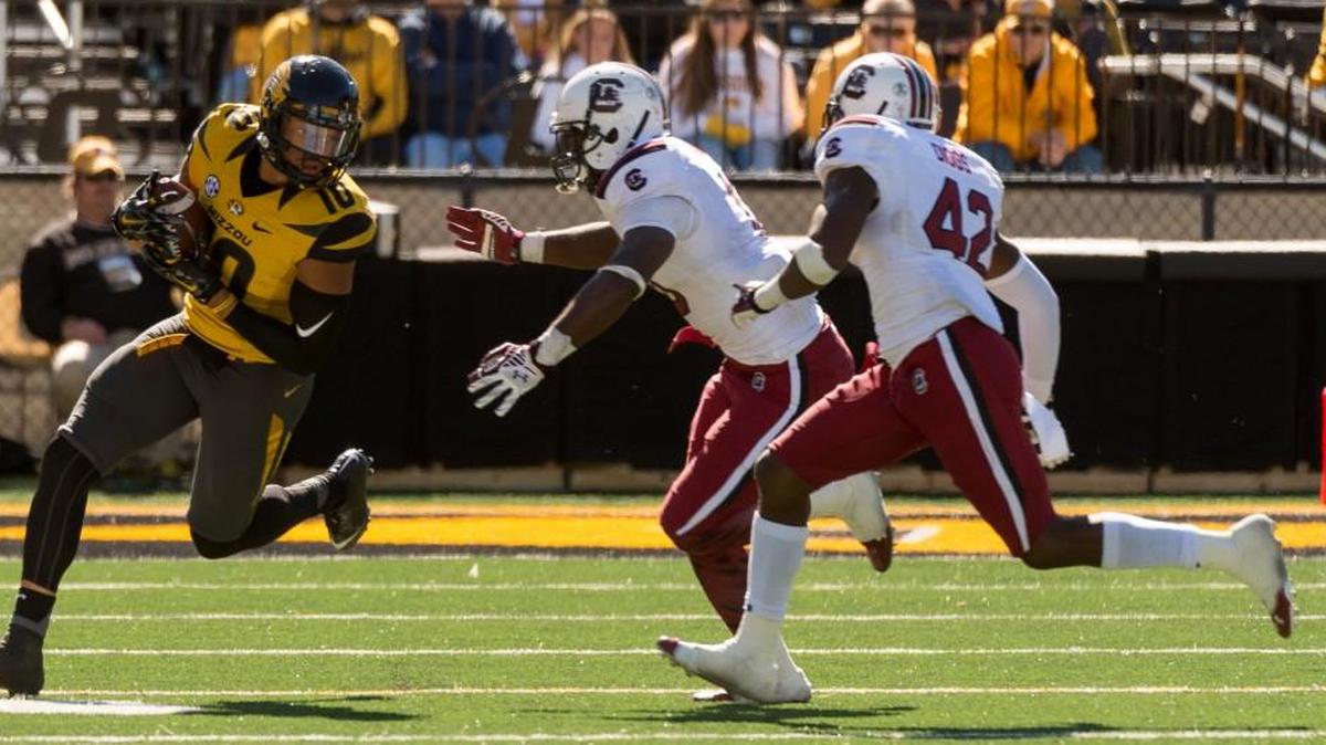 
Missouri tight end Jason Reese, left, runs around South Carolina's Skai Moore, center, and Jordan Diggs, right, during the fourth quarter Saturday.
