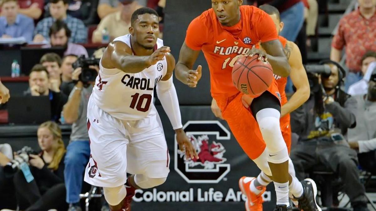Florida's Dorian Finney-Smith grabs a loose ball while defended by South Carolina's Duane Notice during Saturday’s game.
