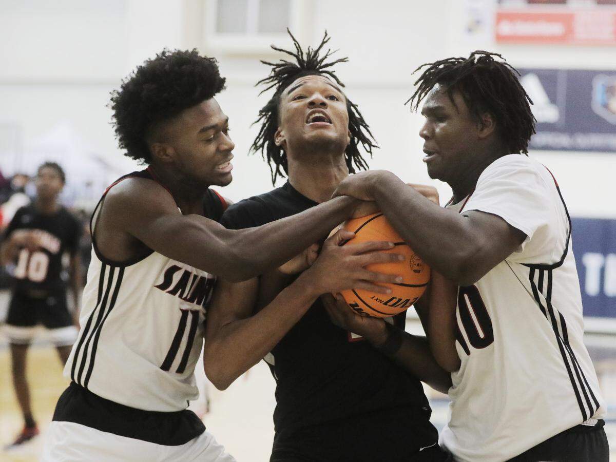 Great Falls’ Tydriez Coleman, middle, fights for control of the ball with Calhoun County’s Christian Zachary (11) and Himan Stready Jr.