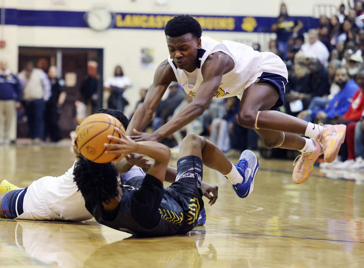 Lancaster’s Malik Tinsley, right, and Jacarey Ballard, left, try to grab the ball from Indian Land’s Michael Jones Friday, Feb. 9, 2024.