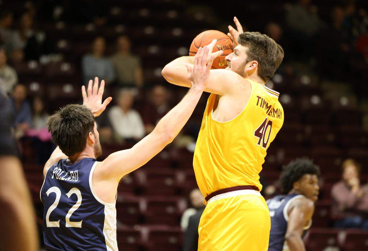 Winthrop’s Alex Timmerman (40) looks for an opening past Queens’ Jaxon Pollard.