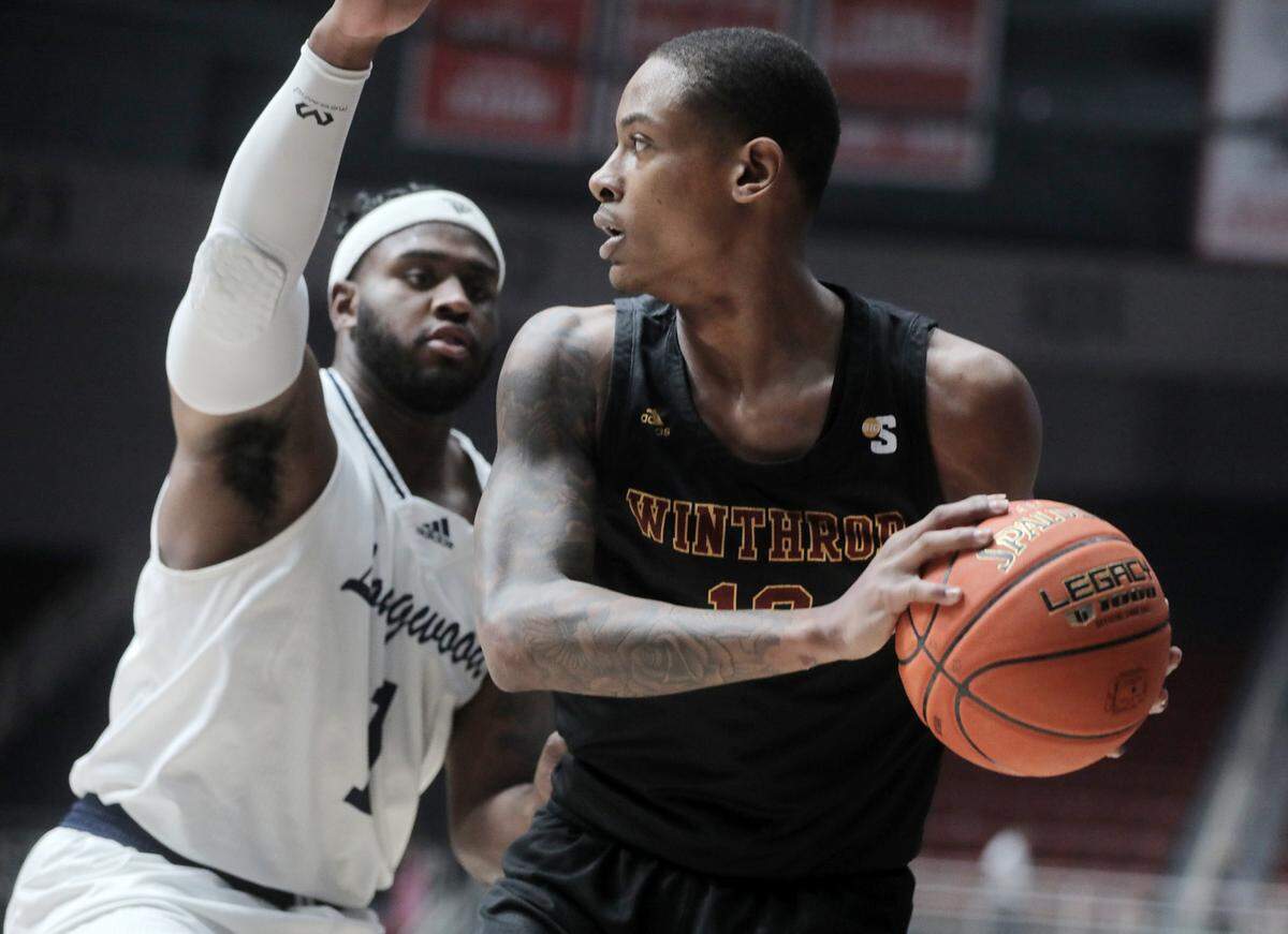 Winthrop’s Cory Hightower looks for an opening against Longwood’s Isaiah Wilkins at the Big South Championship game.