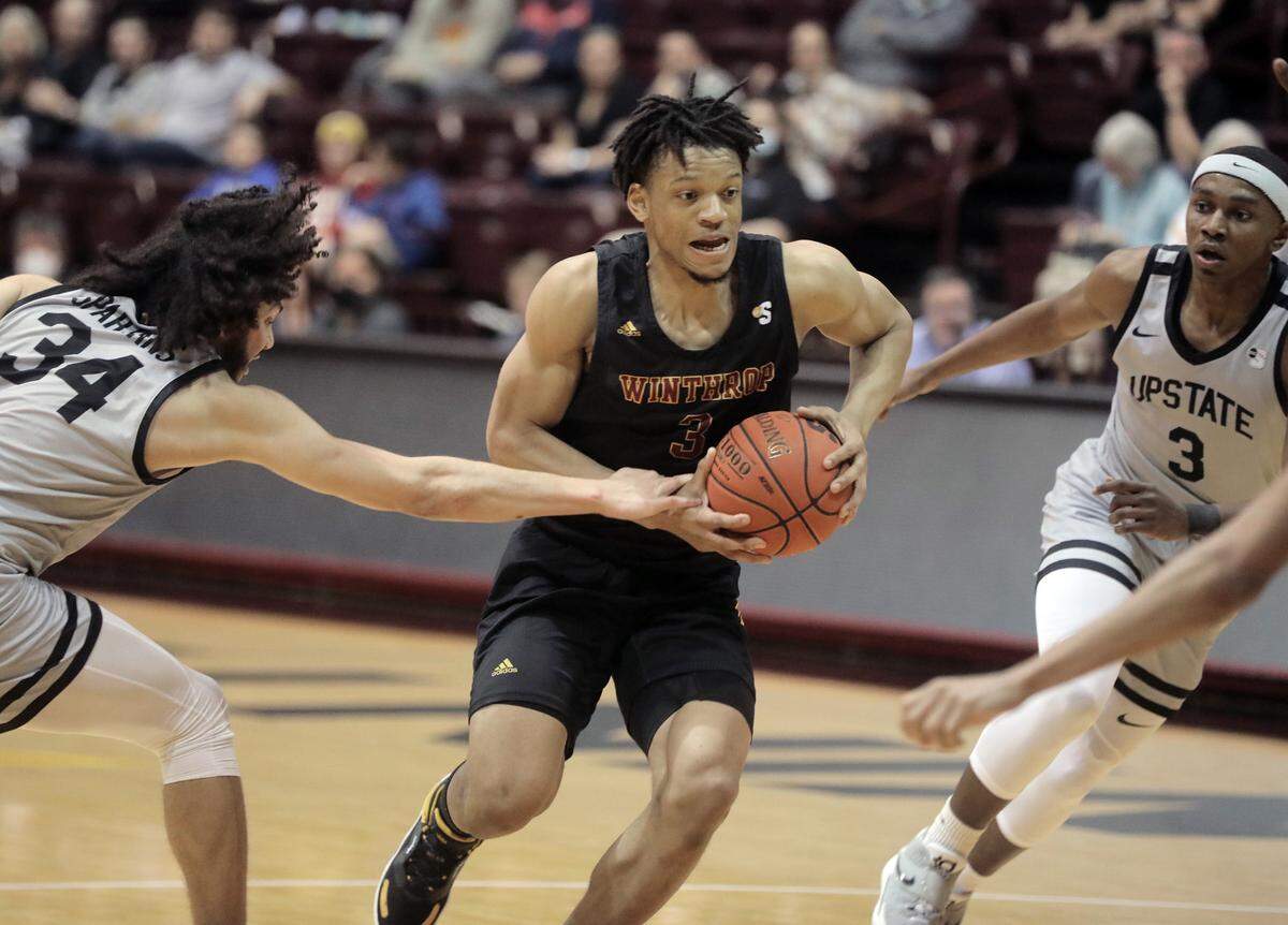 Winthrop’s Michael Anumba heads to the basket against Upstate’s Josh Aldrich (34) and Mysta Goodloe (3).