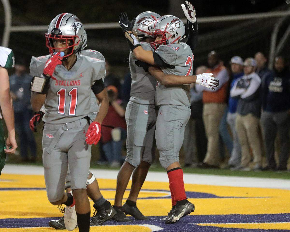 South Pointe’s Jaquan Thompson (23) and Waymond Jenerette celebrate after the Stallions score during teh first half of the state championship game against Beaufort on Thursday in Columbia.
