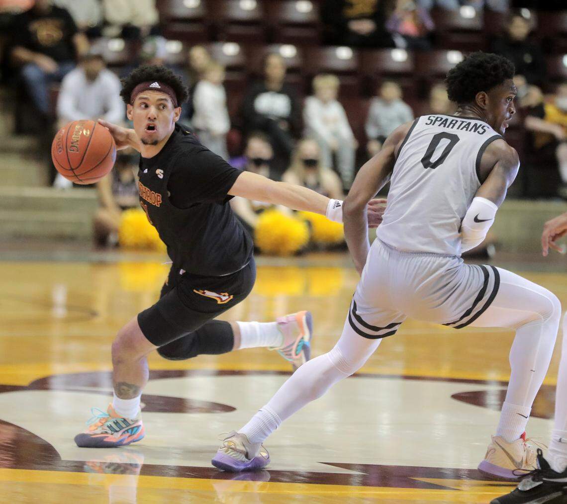 Winthrop’s Drew Buggs looks for an opening around Upstate’s Khydarius Smith (0).