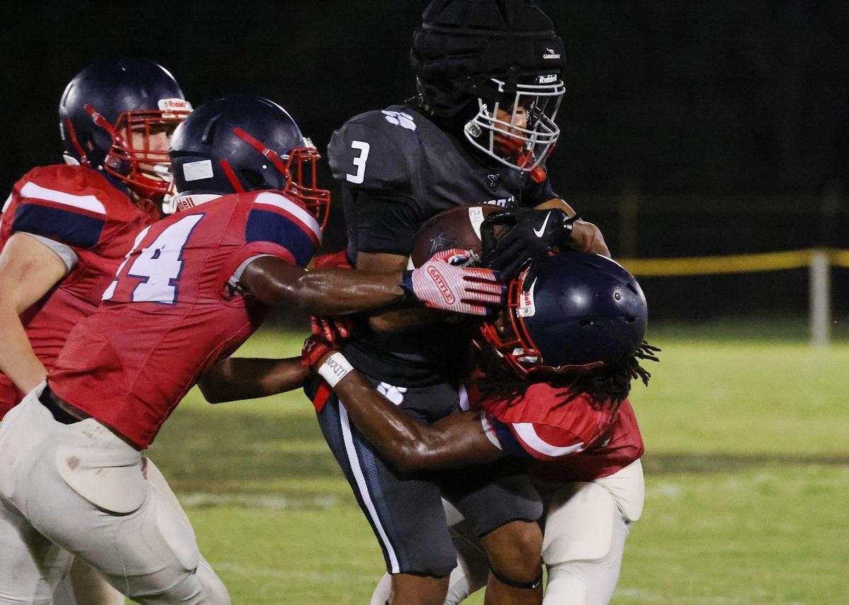 Chester’s Jordan Chisholm (14) and T’Mari Caldwell, right, tackle York’s JR Duncan (0) Friday at a scrimmage in Union.