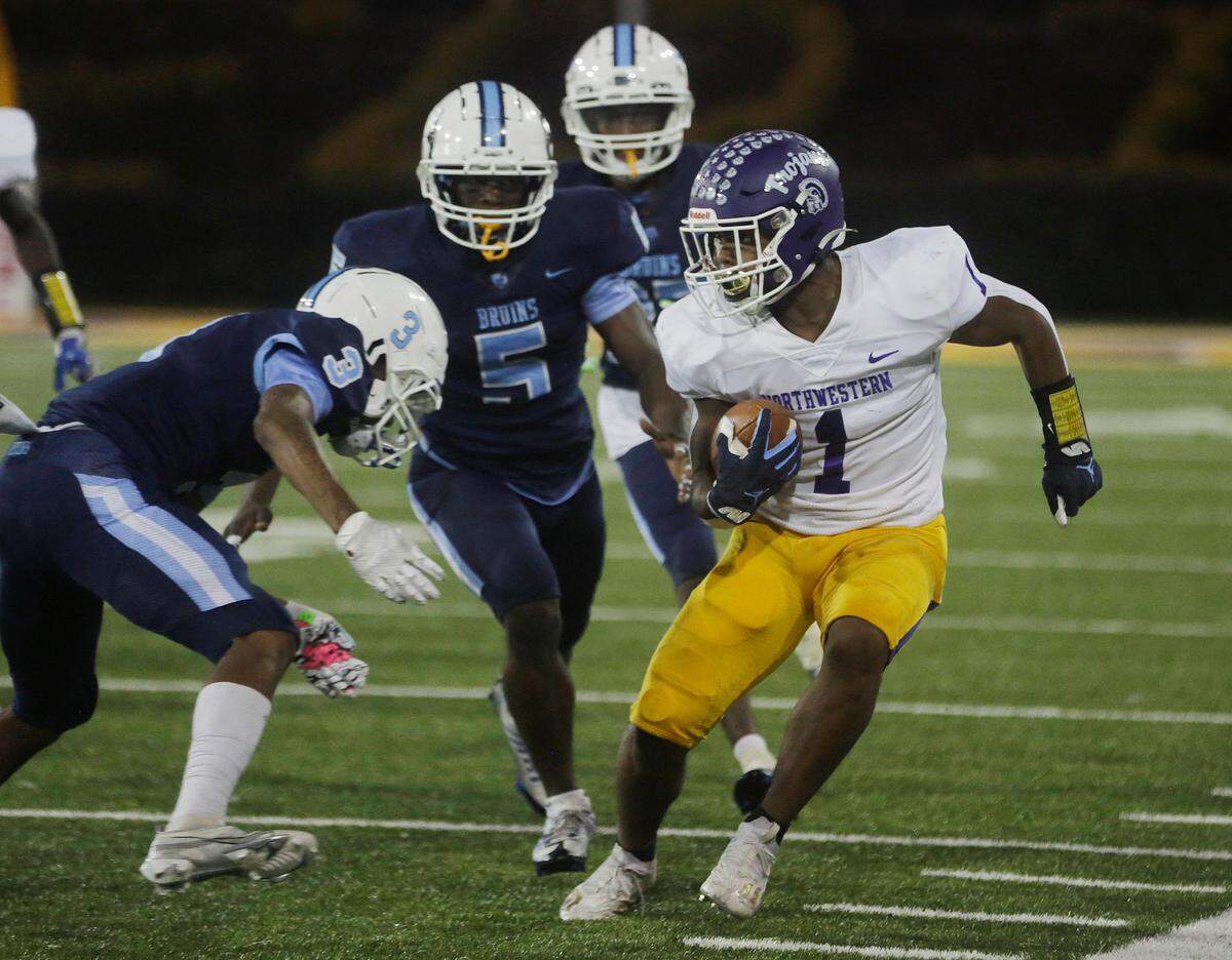 Northwestern’s Turbo Richard (1), tires to avoid South Florence’s Quincy Rhodes Jr. Saturday as the Trojans and Bruins compete for the Class 4A state championship title in Columbia.