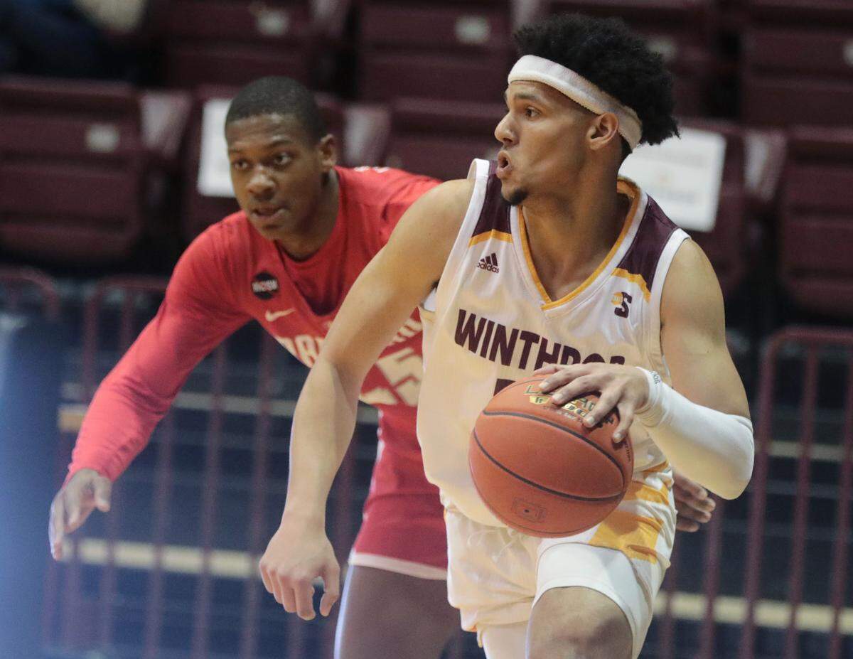 Winthrop’s Drew Buggs looks for an opening around Radford’s Xavier Lipscomb.