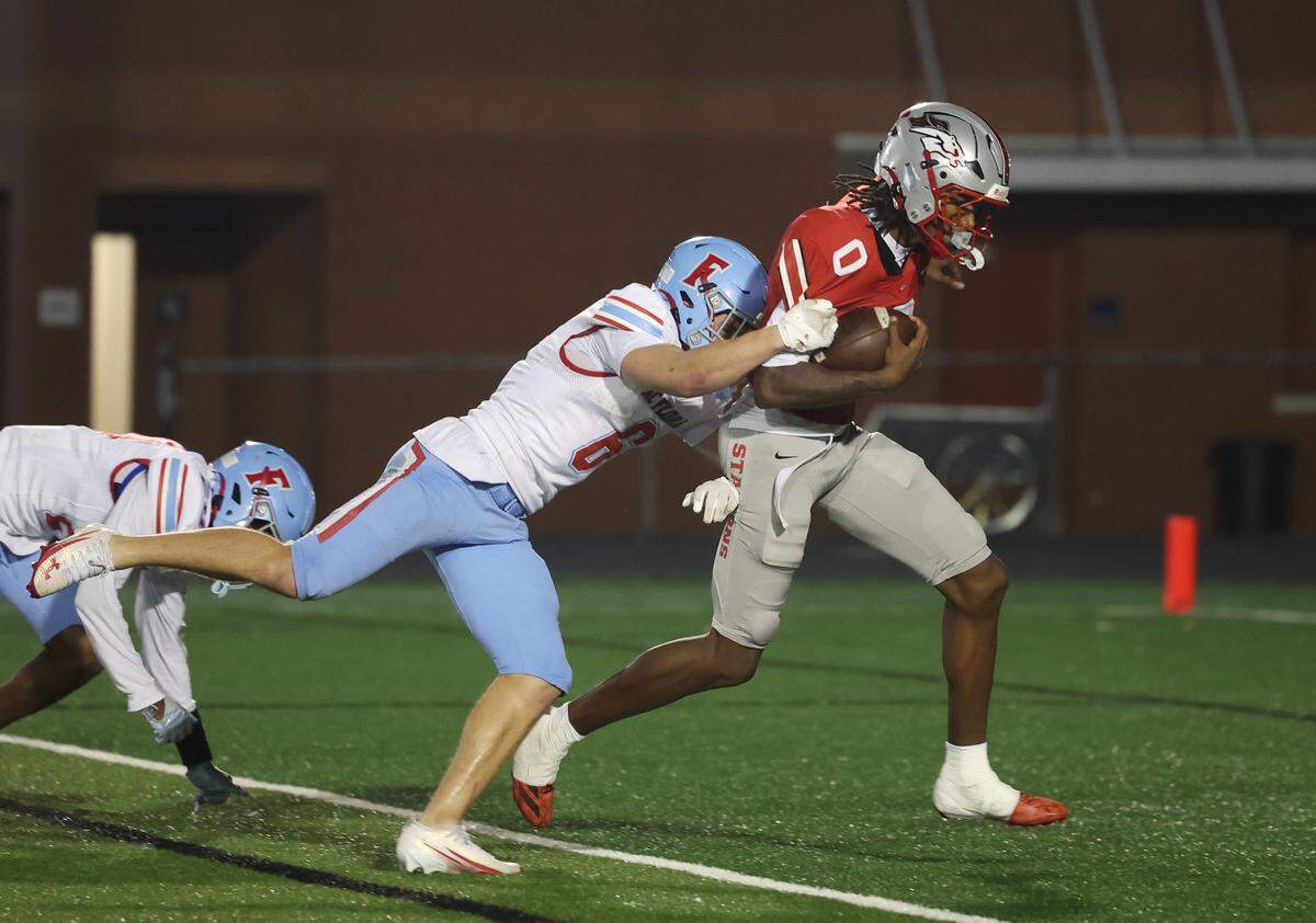 South Pointe's J'zavien Currence (0) scores a touchdown while A.C. Flora's Blake Betette tries to stop him on Friday, Nov. 21, 2025 in Rock Hill, S.C.