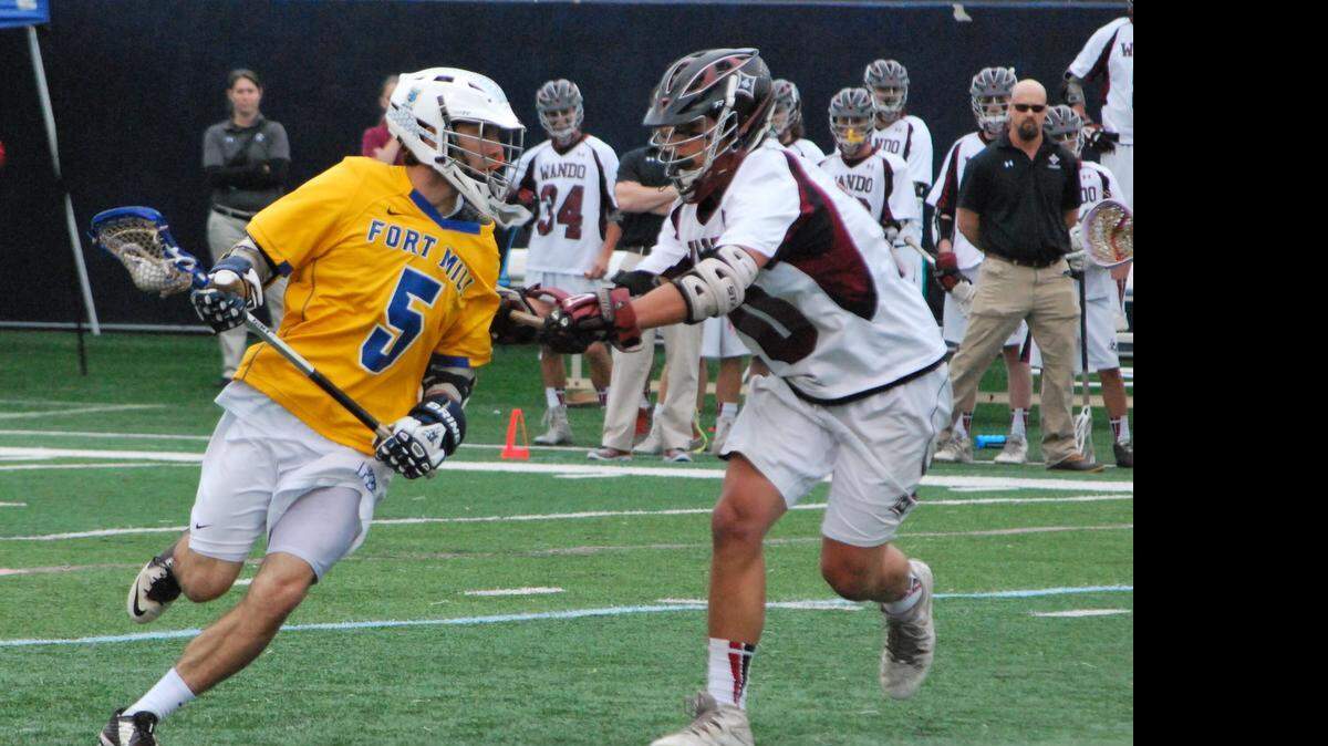 
Fort Mill’s Matt Somjak, left, is closely guarded in Saturday’s state championship lacrosse match against Wando at Chapin High.
