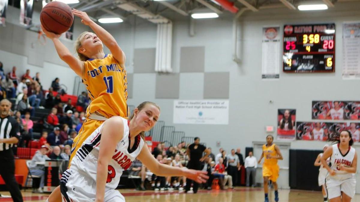 Fort Mill’s Kimber Haley draws the foul while she drives to the basket.