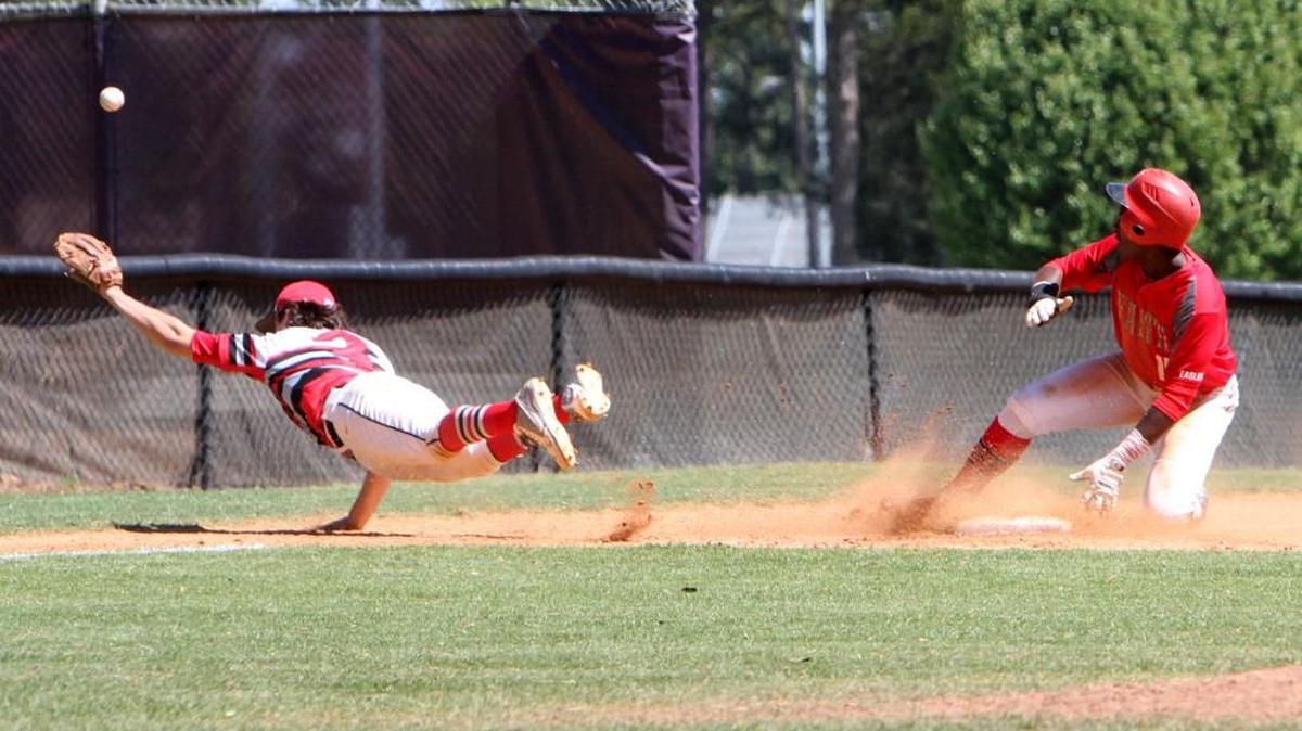 South Pointe's Will Dunn dives for the ball as Faith Baptist's Chavez Young prepares to run home.