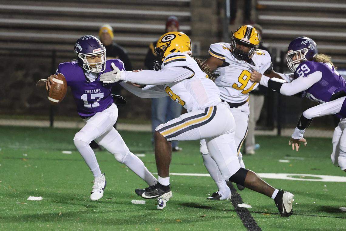 Northwestern’s Xavier Means (17) tries to push off Greenwood’s Nehemiah Cook Friday as the Trojans and Eagles face off in the playoffs.