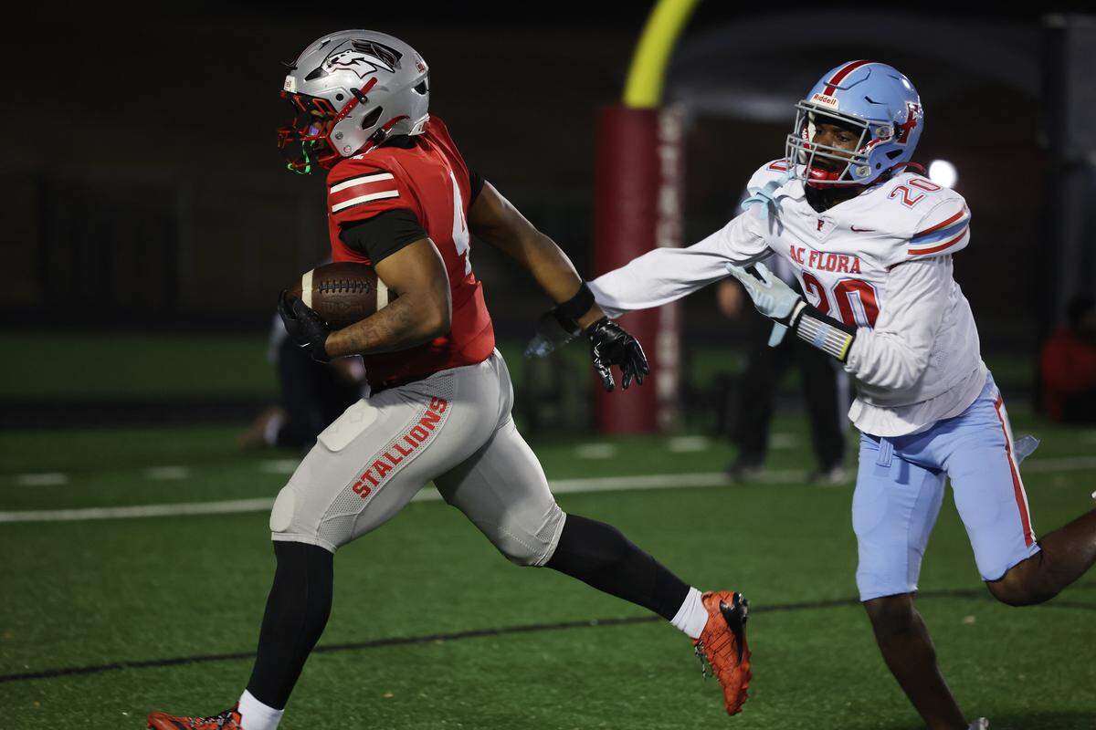 South Pointe's R.J. Brown scores a touchdown as A.C. Flora's Larry Pickett tries to stop him on Friday, Nov. 21, 2025 in Rock Hill, S.C.