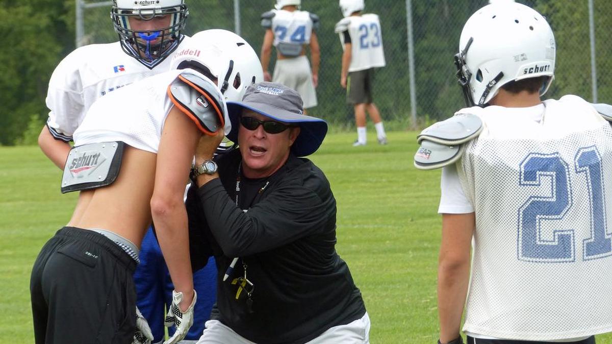 Former Lake Norman High head coach Rob McNeely demonstrates blocking techniques to some of the Wildcats' players during the team's preseason mini-camp in 2015. McNeely has been hired as the new head coach at Fort Mill High.