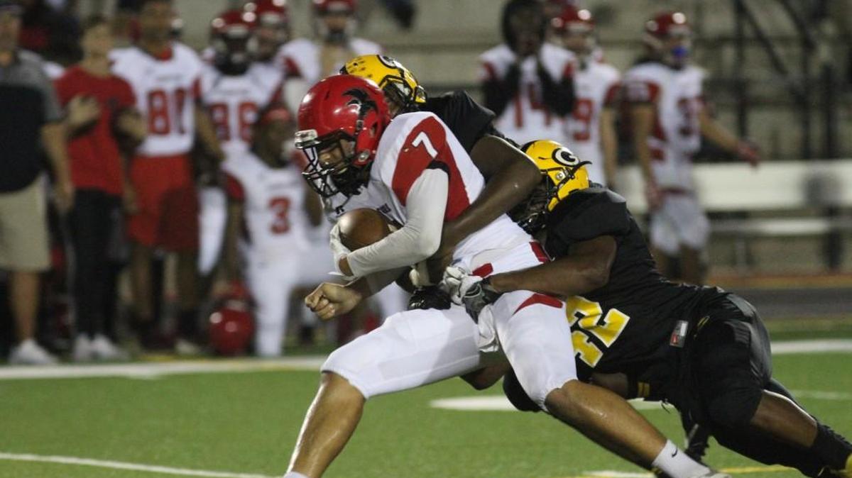 Greenwood defensive linemen Braylon Ryan and DeOndre Kinard take down Nation Ford quarterback Ben Tuipulotu Friday during the Eagles' 35-14 first-round playoff win at J.W. Babb Stadium.