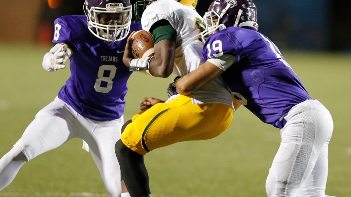 Laurens’ Chris Statom is taken down by Northwestern defenders Debrele Williams, left, and Miles Corprening during Northwestern’s win over Laurens at District Three Stadium on Friday .