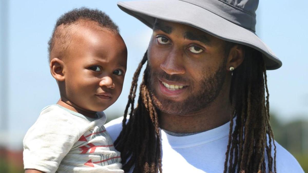 Former South Pointe High School and NFL standout Stephon Gilmore holds his 15-month-old son Sebastian Tuesday at South Pointe High School. Gilmore hosted his second youth football camp at the school.