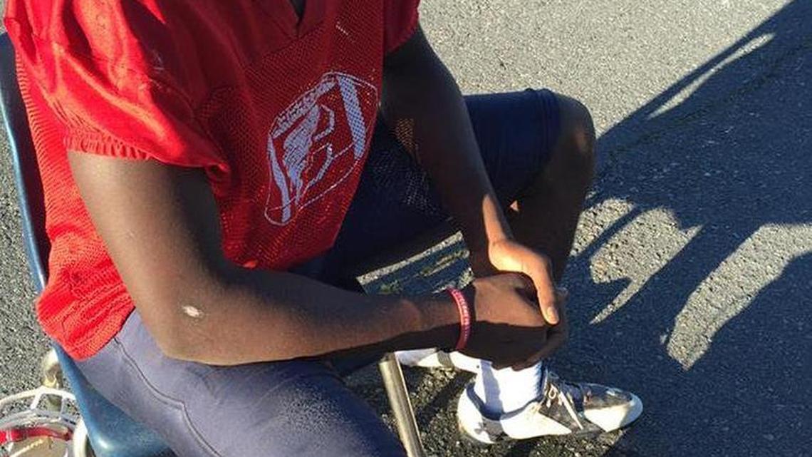 In a photo from 2015, since graduated Chester High football player Albert Thompson watched practice while his sprained ankle sat in a vinegar and red clay compress intended to reduce swelling. Chester coach Victor Floyd has long used the remedy he learned from his grandmother.