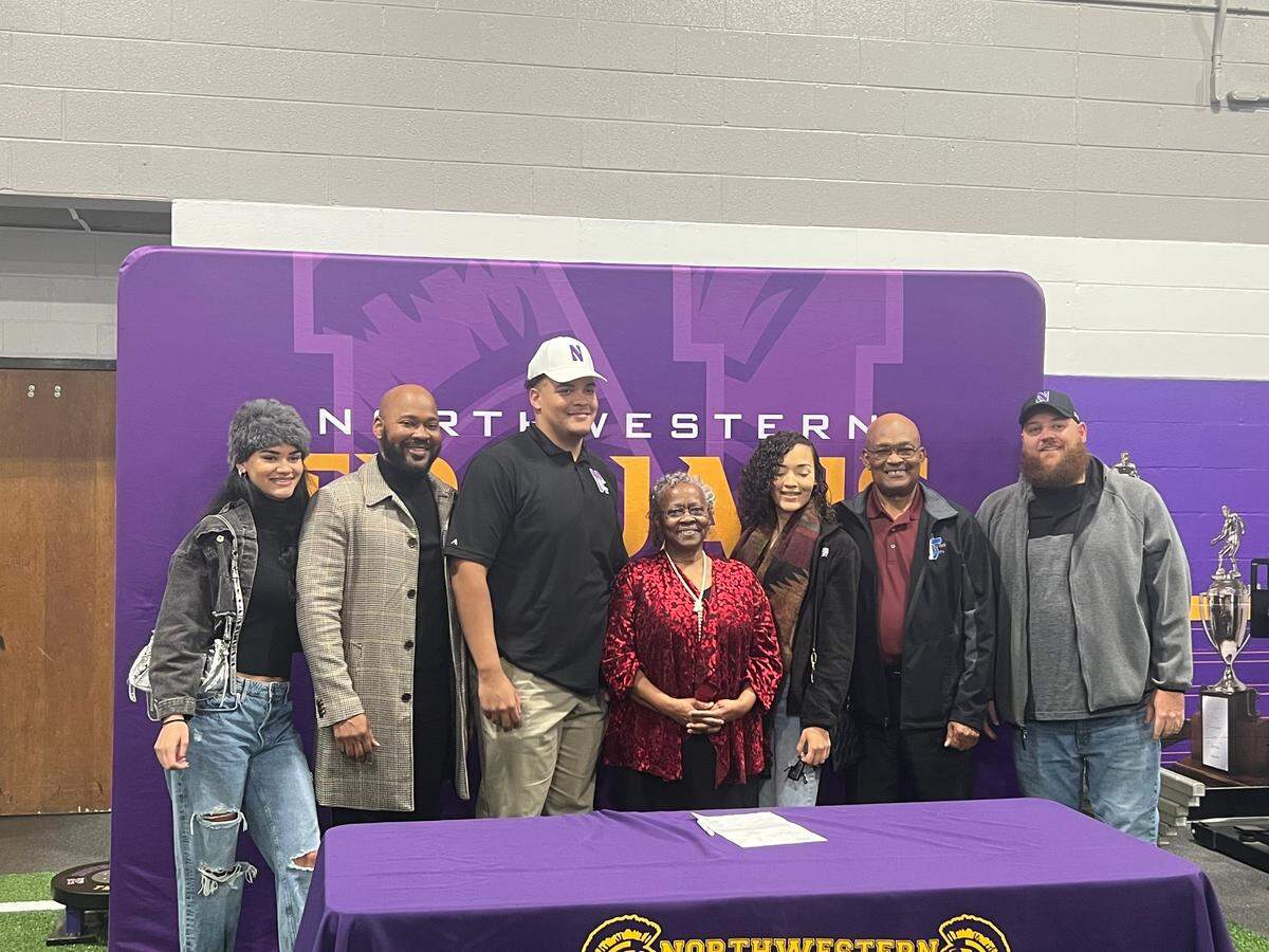 Knox (third from left, white hat) poses for pictures with his family at his early signing day.