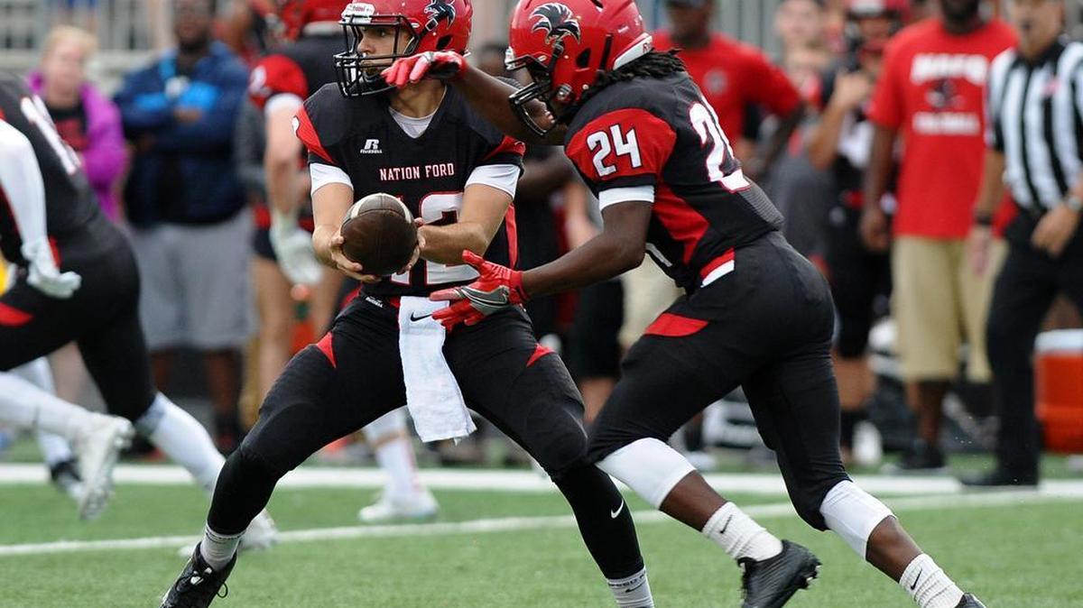 Quarterback Kirk Rygol (12) fakes the hand off to running back Jaylen Keels (24) on the quarterback keeper.
