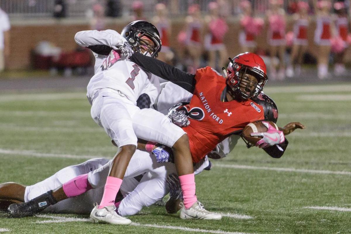 Nation Ford’s Dawaun McCullum (8) stretches for extra yards as he is pulled down by a pair of Bearcats Friday.
