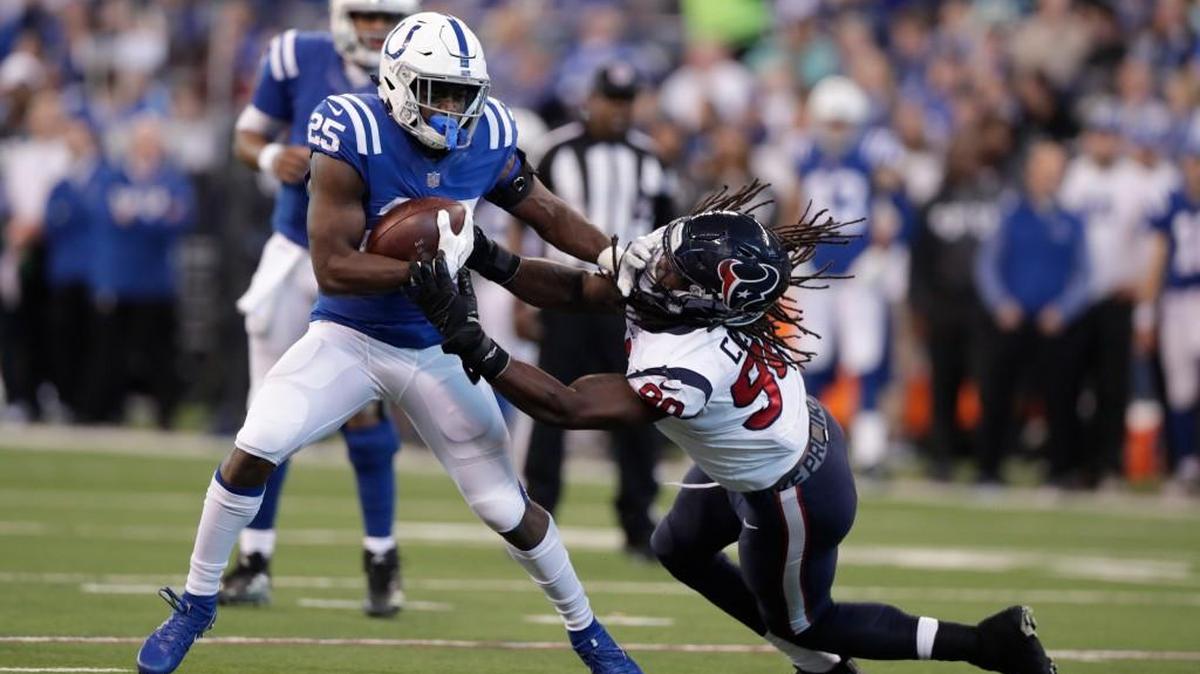 Indianapolis Colts' Marlon Mack (25) runs out of the tackle of Houston Texans' Jadeveon Clowney (90) during the second half of an NFL football game, Sunday, Dec. 31, 2017, in Indianapolis.