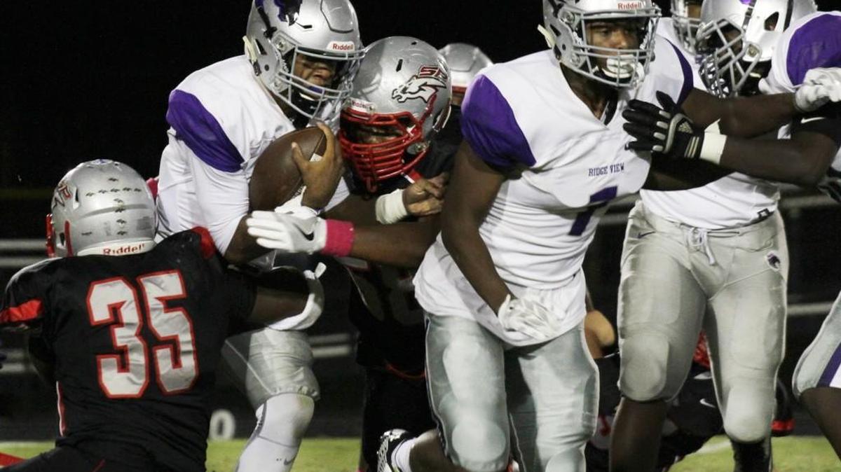 South Pointe's DaQuan Brown, center, and Jalen Hicks (35) try to tackle Ridge View's Jalen Smith.