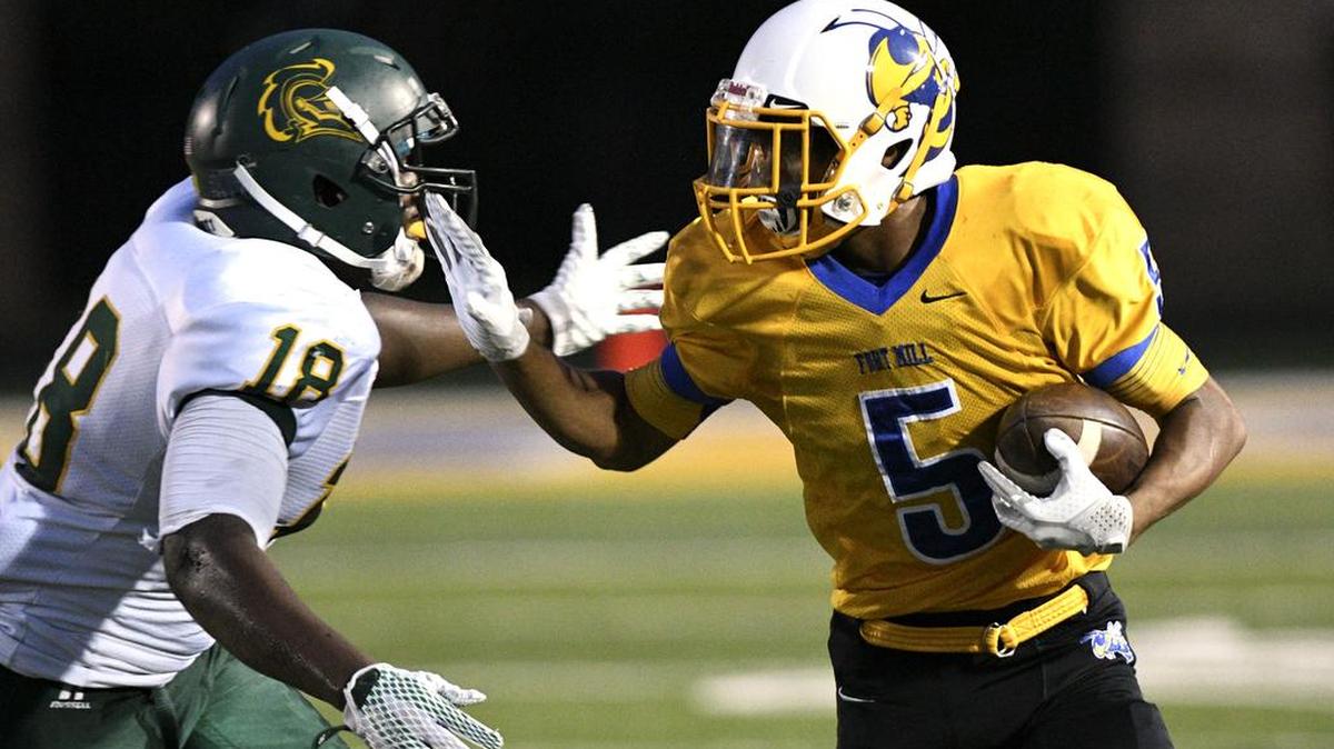 Fort Mill's Josh Cloud (5) stiff-arms West Florence's Dakyas Belser (18) as he heads to the outside on a run play in the first half Friday at Fort Mill.