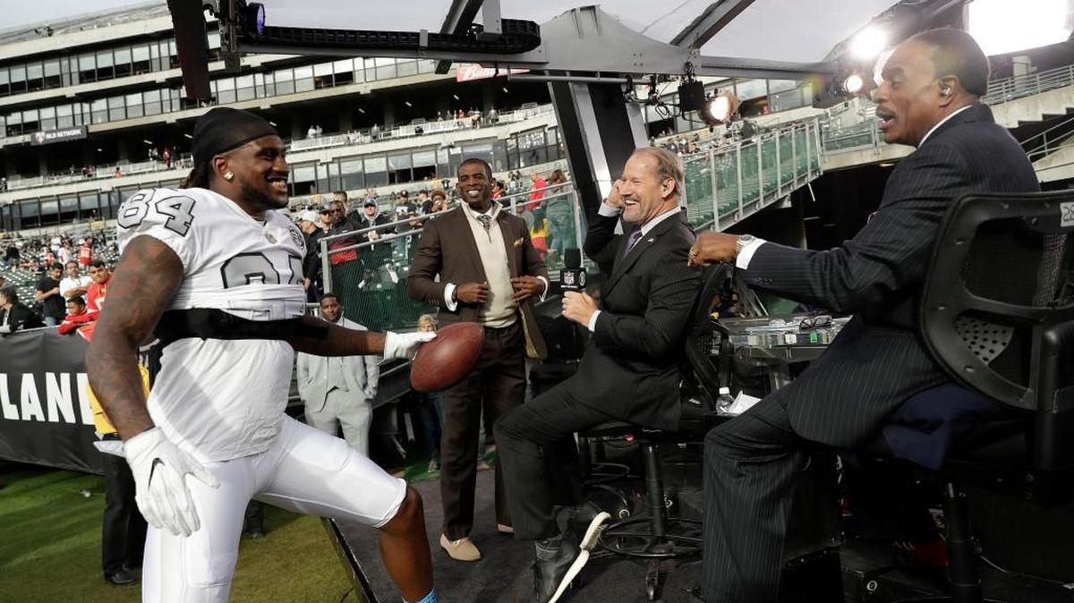Oakland Raiders wide receiver Cordarrelle Patterson (84) greets broadcasters Deion Sanders, from center, Bill Cowher and James Brown before an NFL football game between the Raiders and the Kansas City Chiefs in Oakland, Calif., Thursday, Oct. 19, 2017.