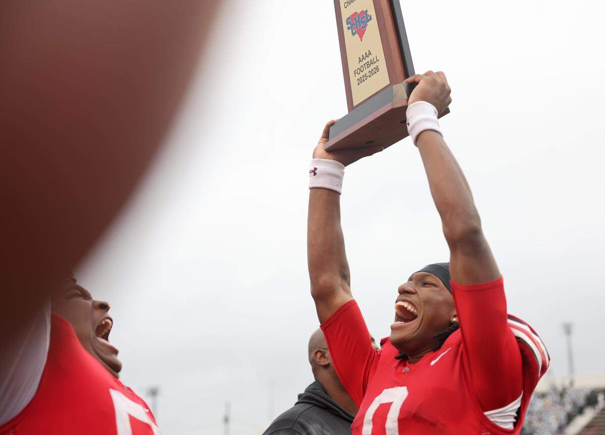 South Pointe's J'zavien Currence, right, and Jaydon Lee celebrate with the championship trophy Saturday at the SC High School League Class 4A football championship